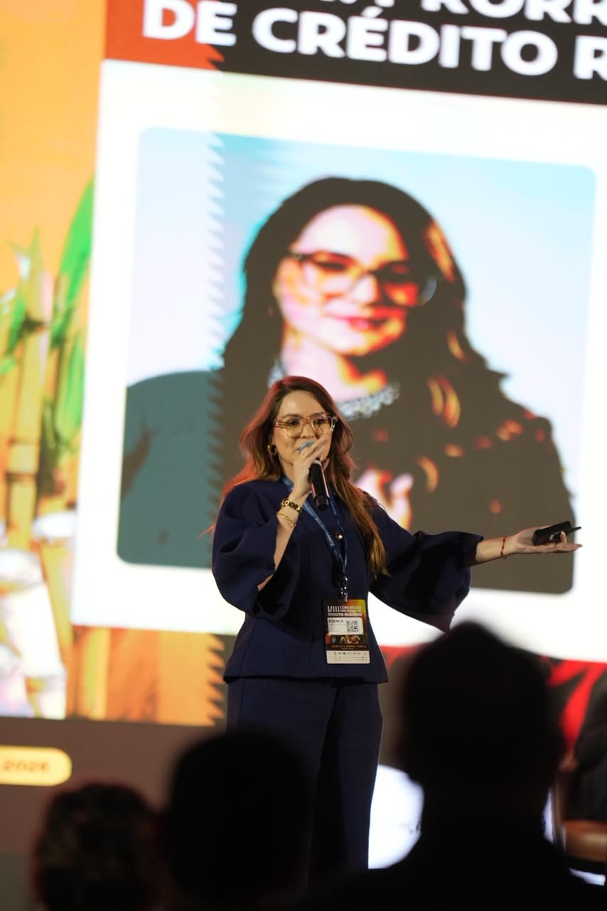 Dra. Bianca Nascimento palestrando sobre crédito e direito bancário — imagem completa no palco